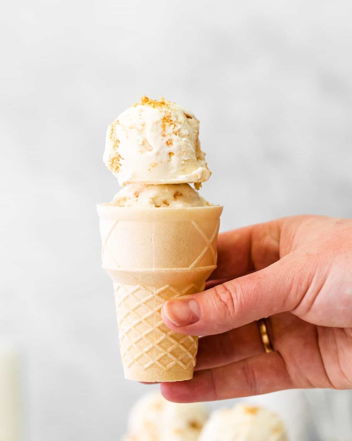 A wafer ice cream cone with cheesecake ice cream in it.