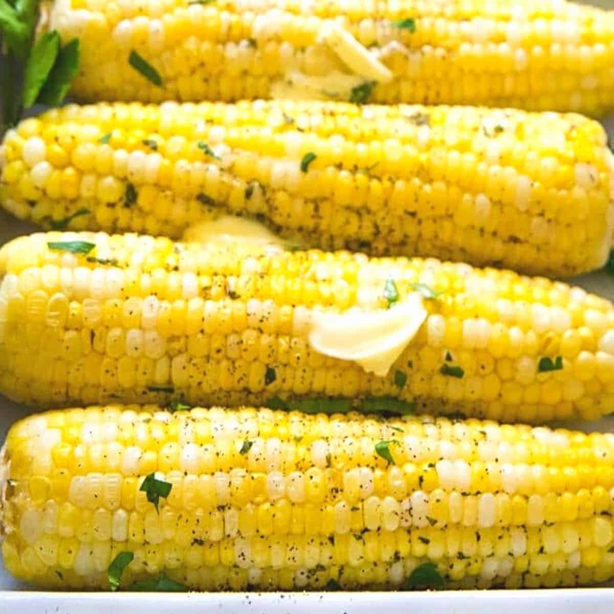 Roasted corn on the cob topped with butter, pepper, and herbs.