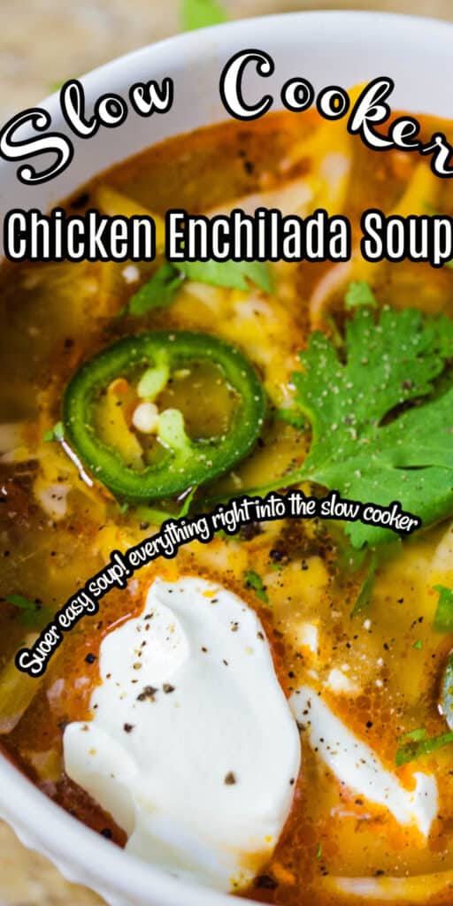 Enchilada soup in a white soup bowl topped with sour cream and sliced jalapeno.