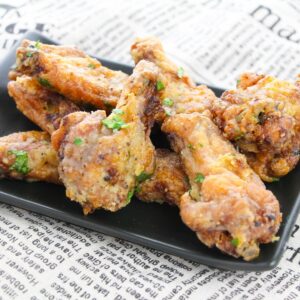 Lemon pepper wings on a black plate.