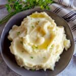An overhead view of homemade mashed potatoes with melting butter on top.