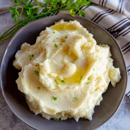 An overhead view of homemade mashed potatoes with melting butter on top.