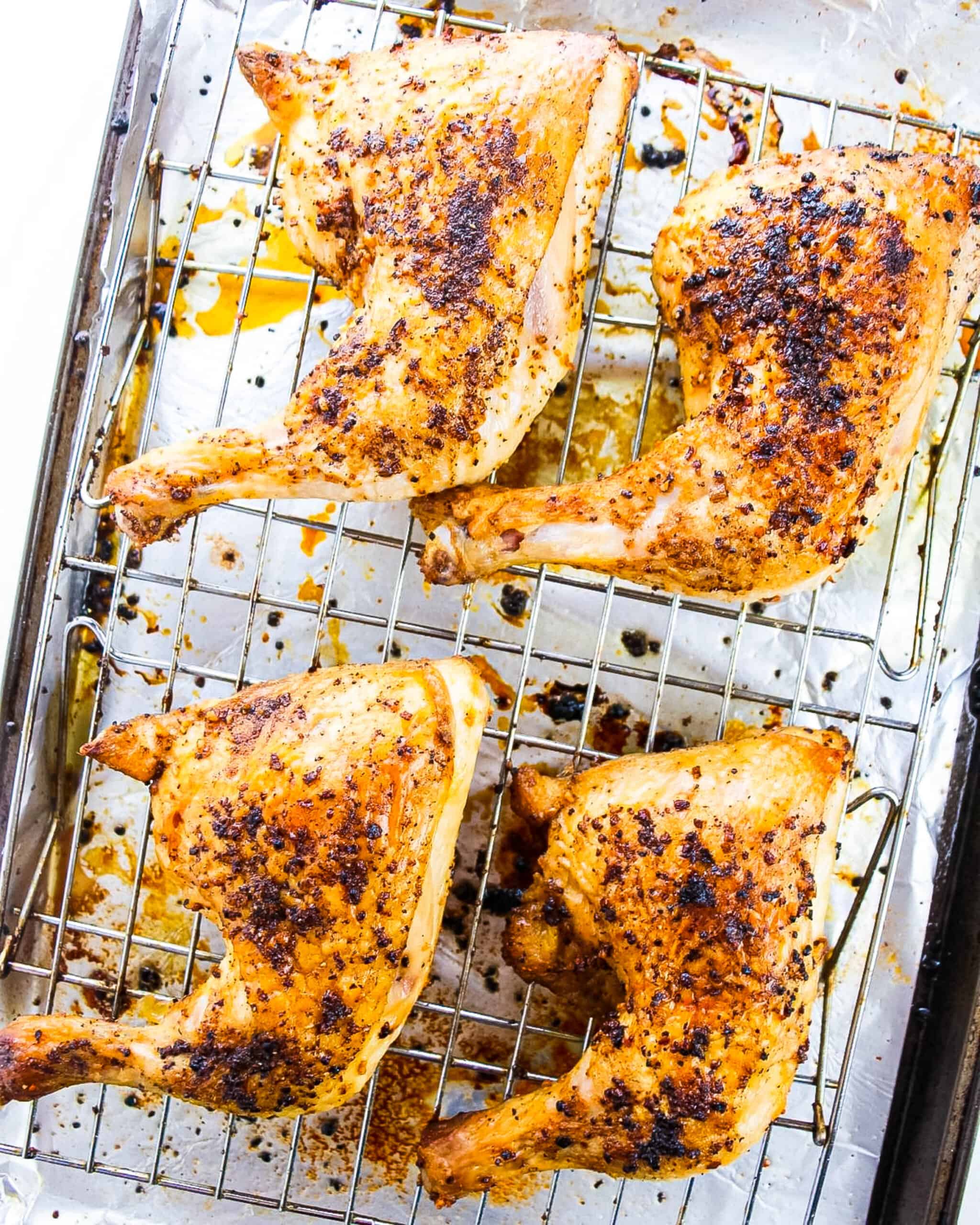 Chicken leg quarters baked on a wire rack. 