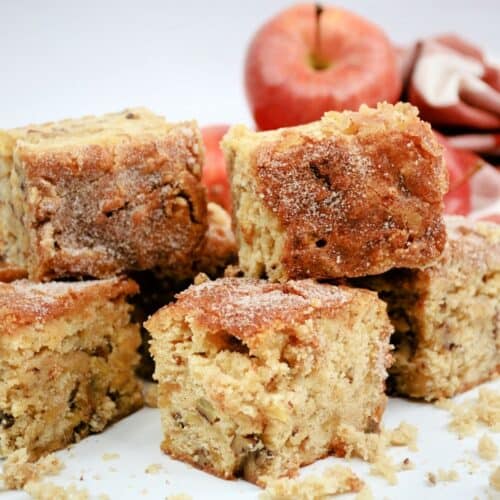Slices of blondies with red apples behind them.
