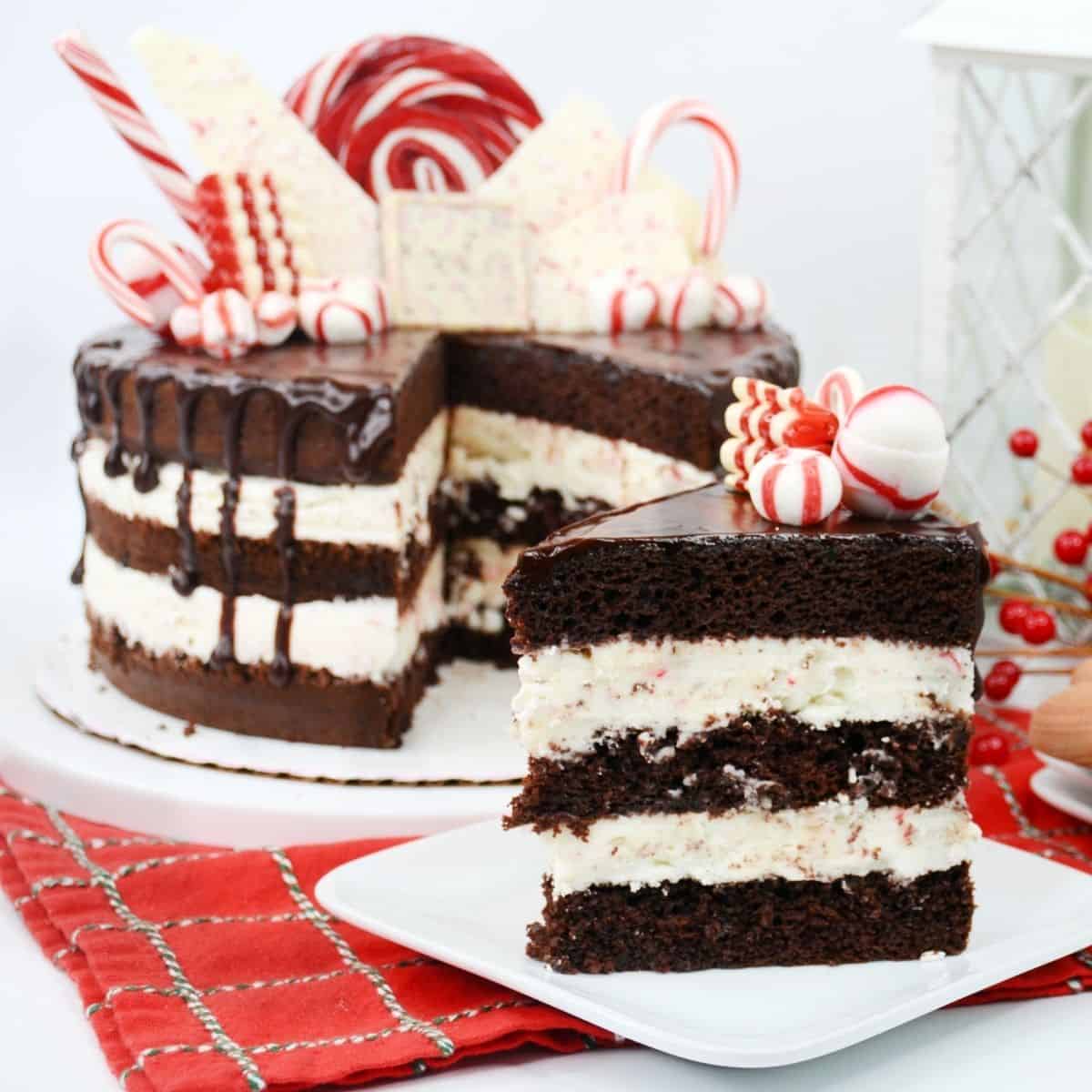 A chocolate peppermint candy cane cake with a slice cut out on a separate plate.