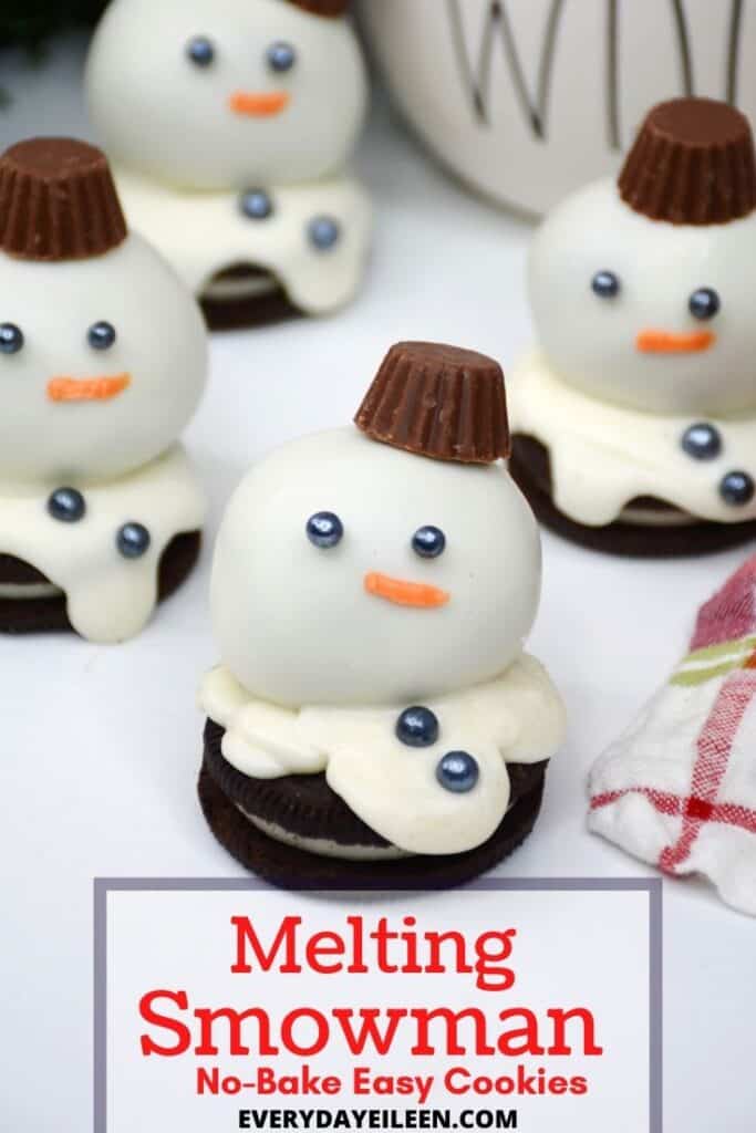 A chocolate sandwich cookie topped with a white covered truffle depicting a snowman.