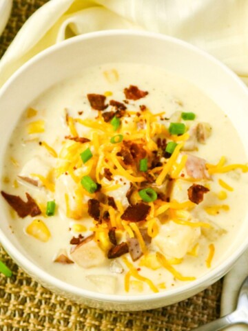 Slow Cooker Corn Chowder in a bowl topped with bacon and green onion.