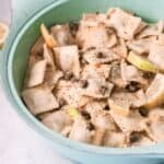 Piccata sauce with capers and lemon over ravioli in a green serving bowl.