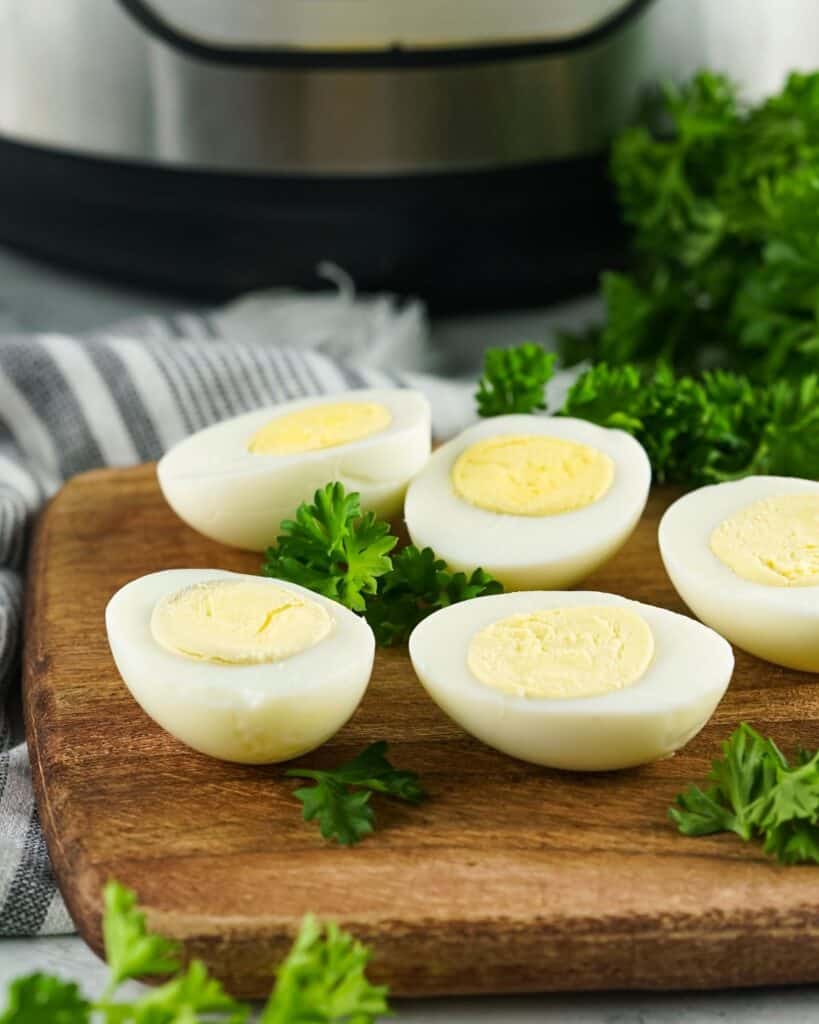 Sliced cooked eggs that are hard boiled in the instant pot on a cutting board. 