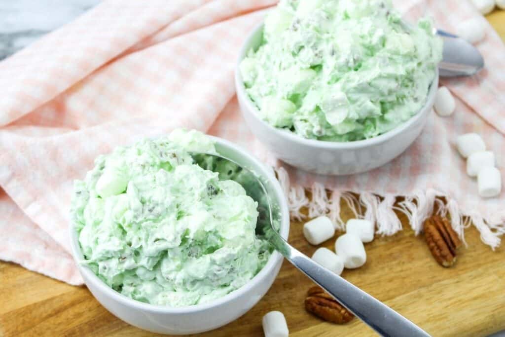Watergate salad in bowls with marshmallows and pecans on the side. 