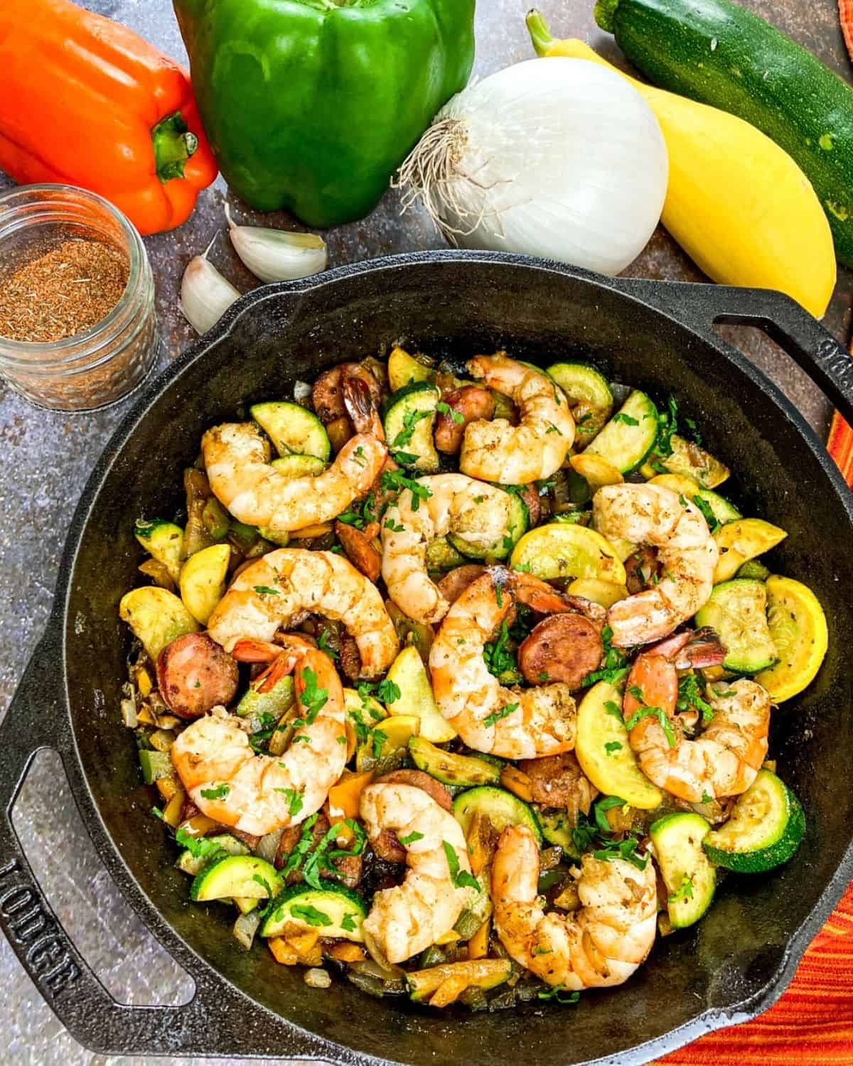 A cast iron skillet with shrimp and sausage 