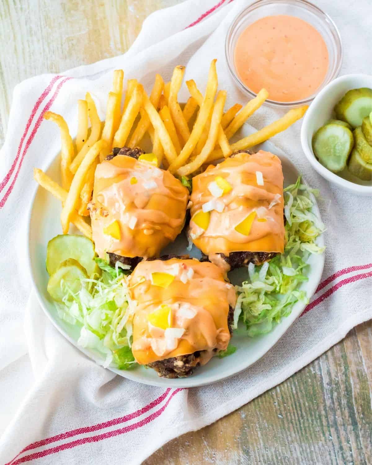 Big mac meatloaf topped with cheese and special sauce on a plate.