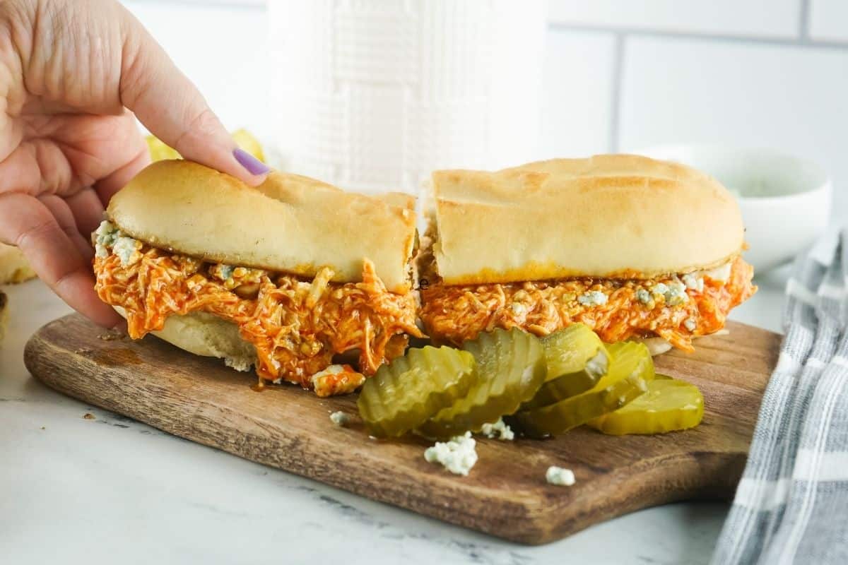 Slow Cooker Shredded Chicken Sandwich with Buffalo Sauce with pickles on the side. 