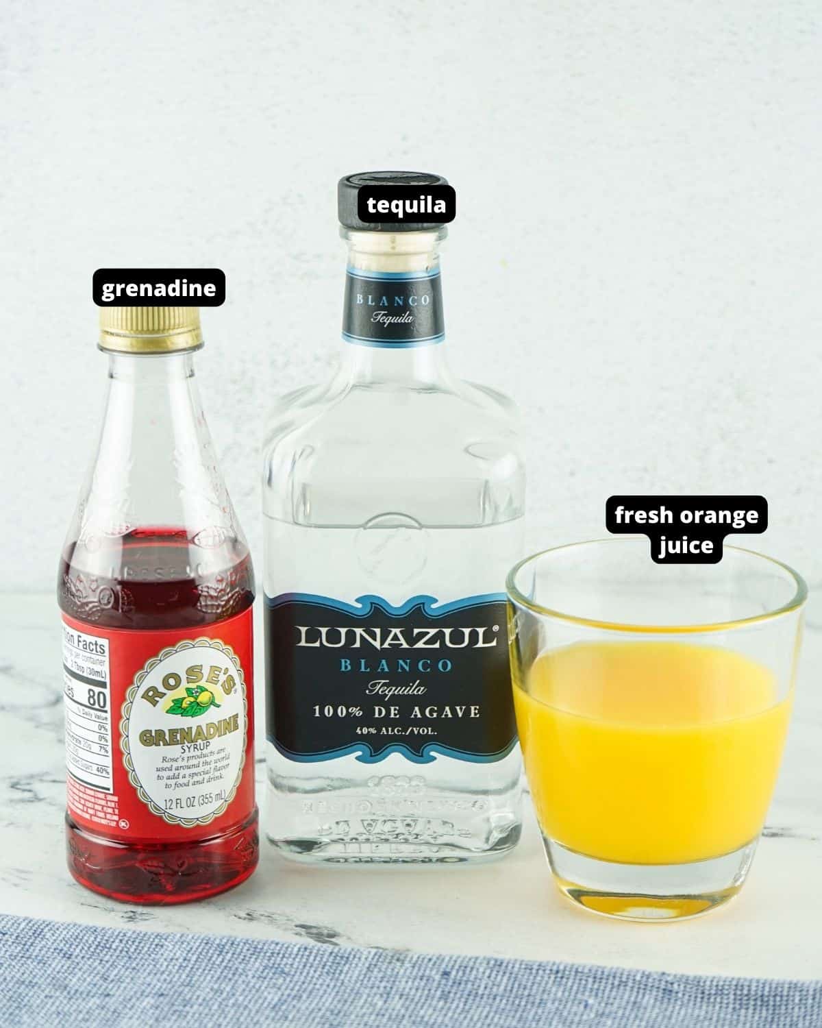 The ingredients to make tequila sunrise cocktail, tequila, grenadine, fresh orange juice