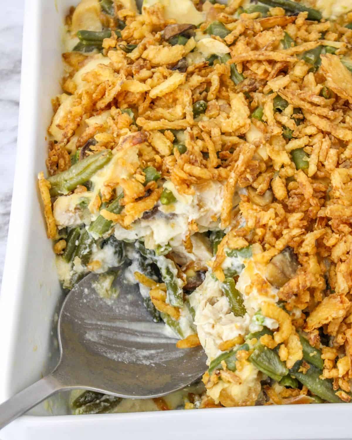 A creamy chicken green bean casserole with mushrooms with crispy onions on top. 