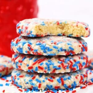 Sprinkle cookies stacked on a plate.