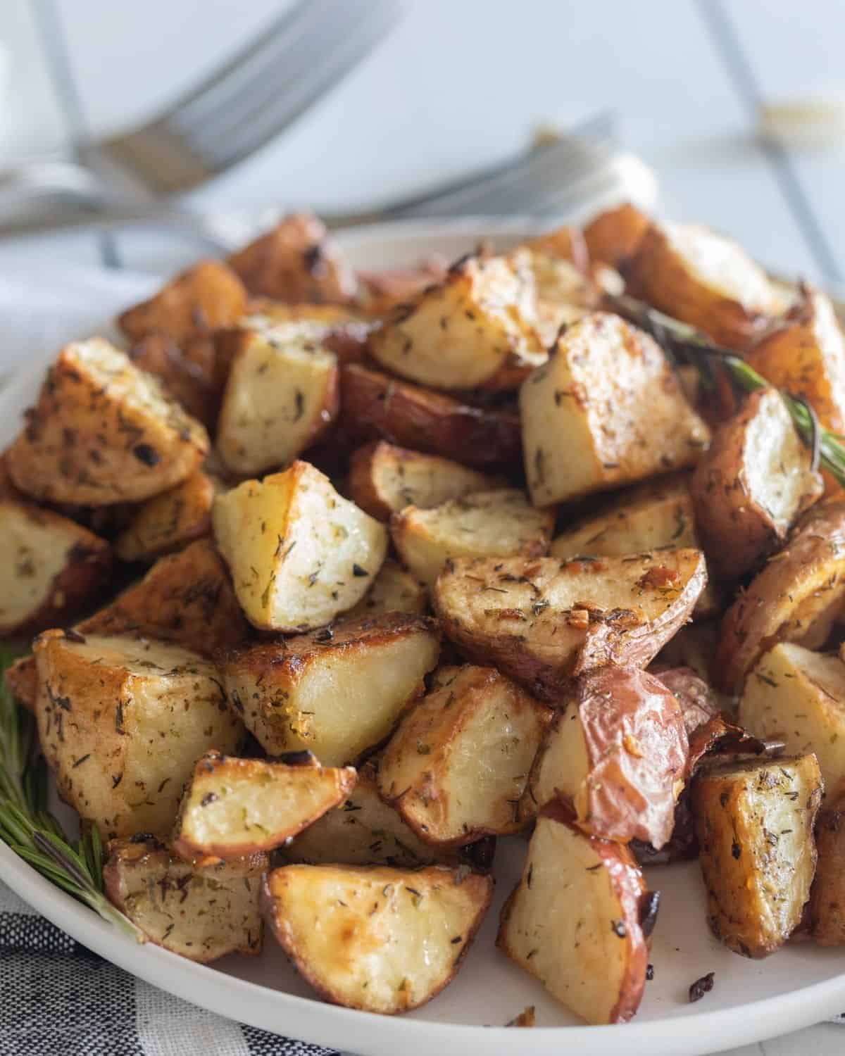 Roasted Garlic Red Potatoes baked and served in a large white bowl. 