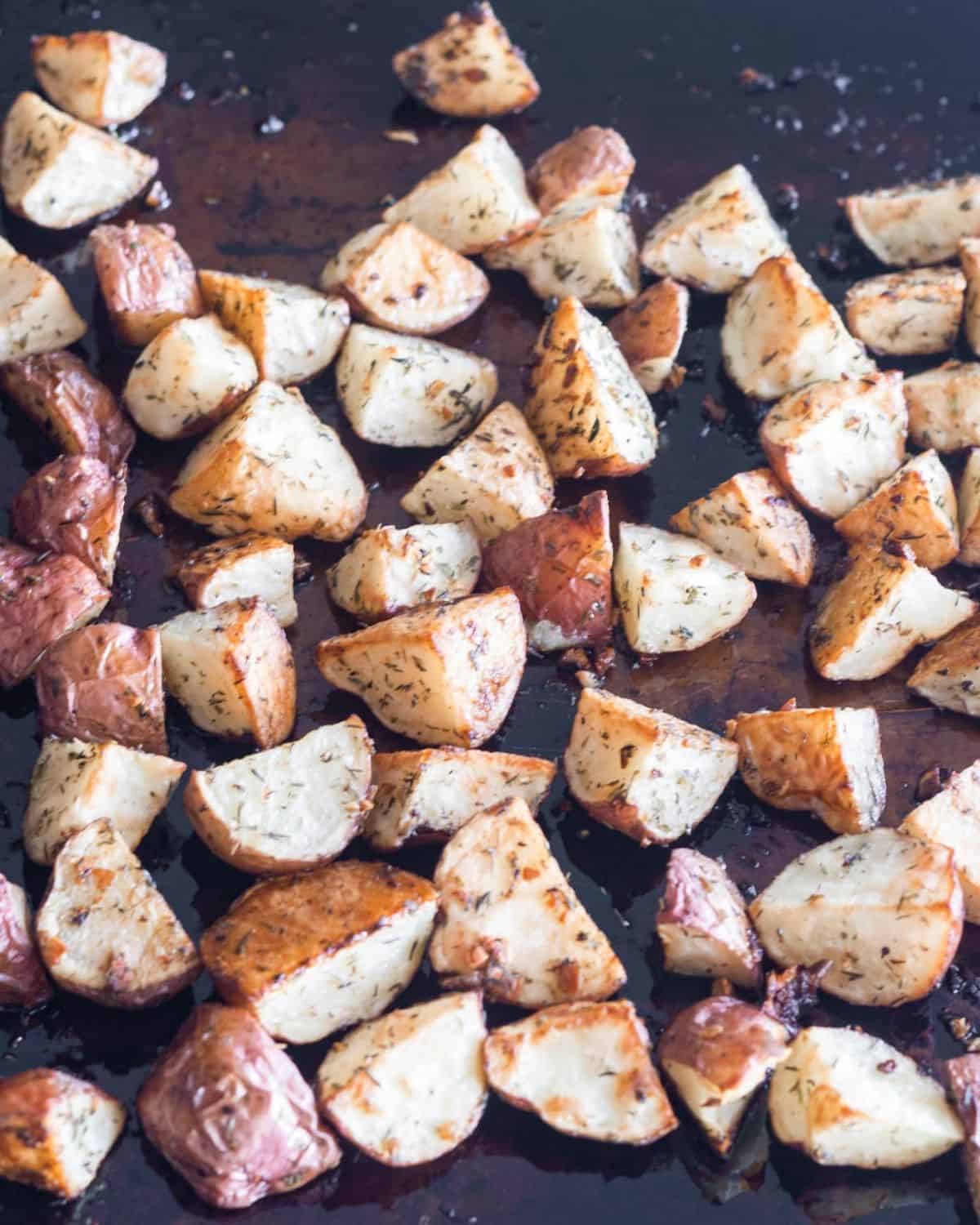 A sheet pan with cubed red potatoes on it. 