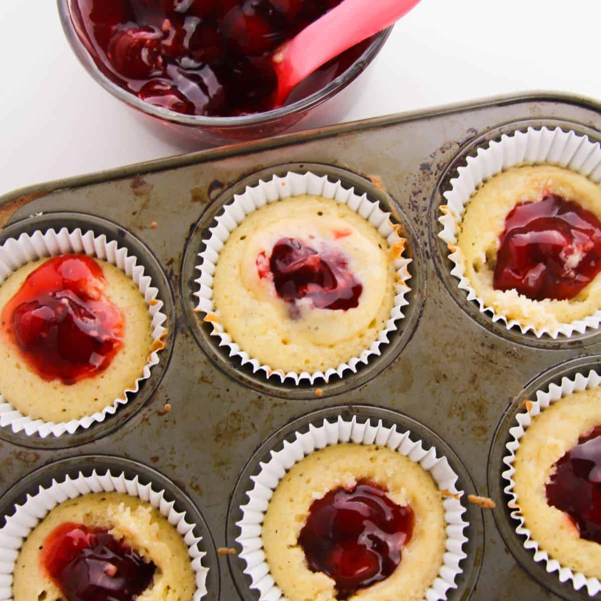 A cupcake tip with vanilla cupcakes with cherry pie filling in each cupcake.