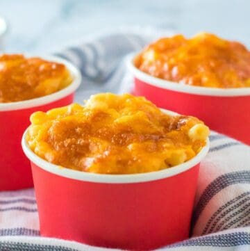 Three cups of mac and cheese top with melted cheese