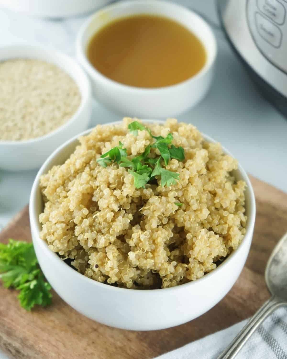 A white bowl filled with cooked quinoa topped with parsley. 