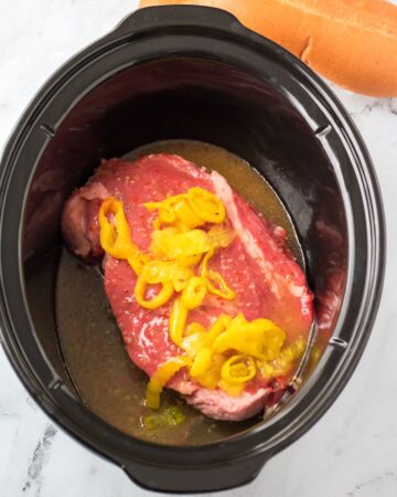 Slow cooker Italian beef with zesty Italian dressing and pepperoncini peppers.