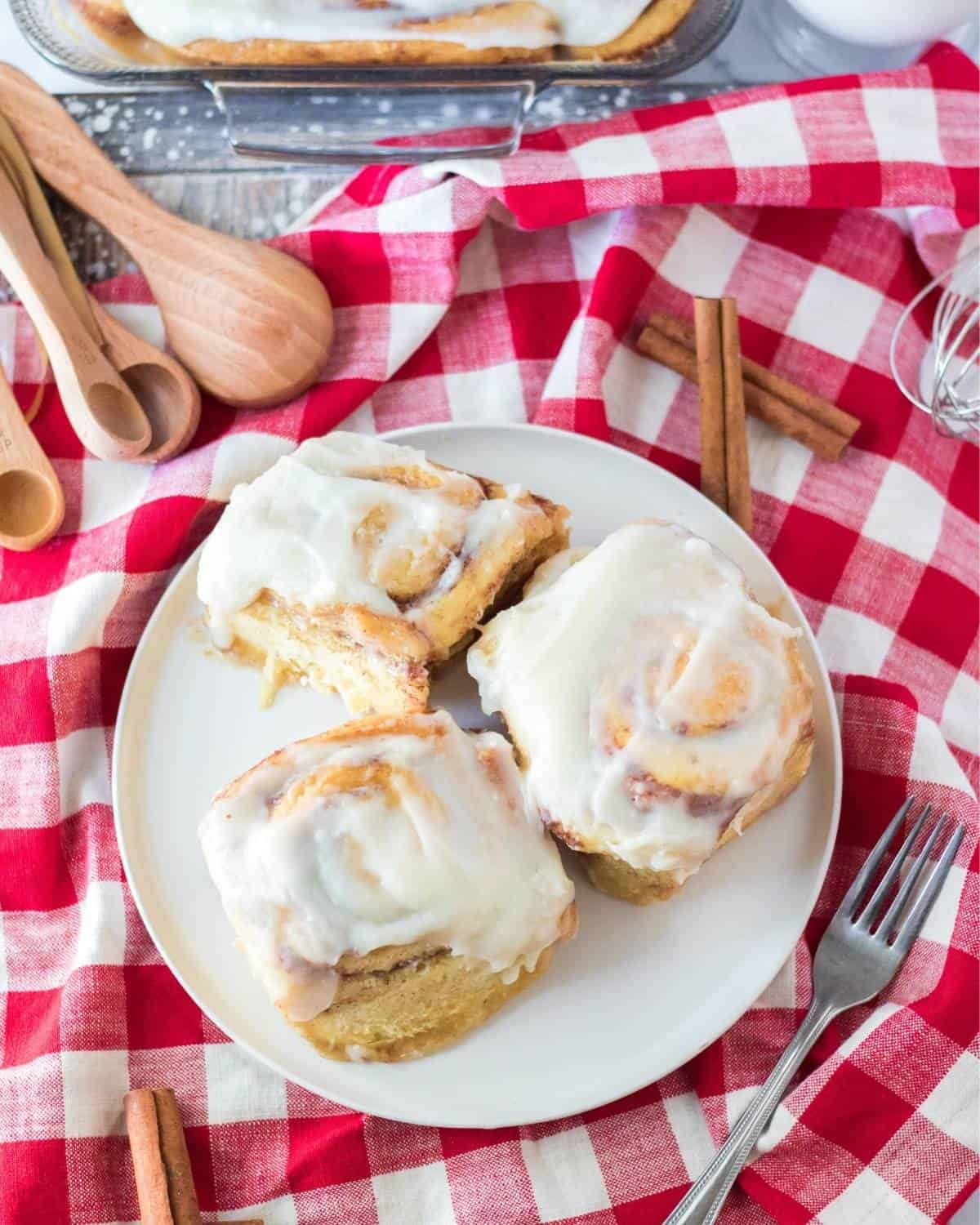 An overhead view of cinnamon rolls topped with frosting.