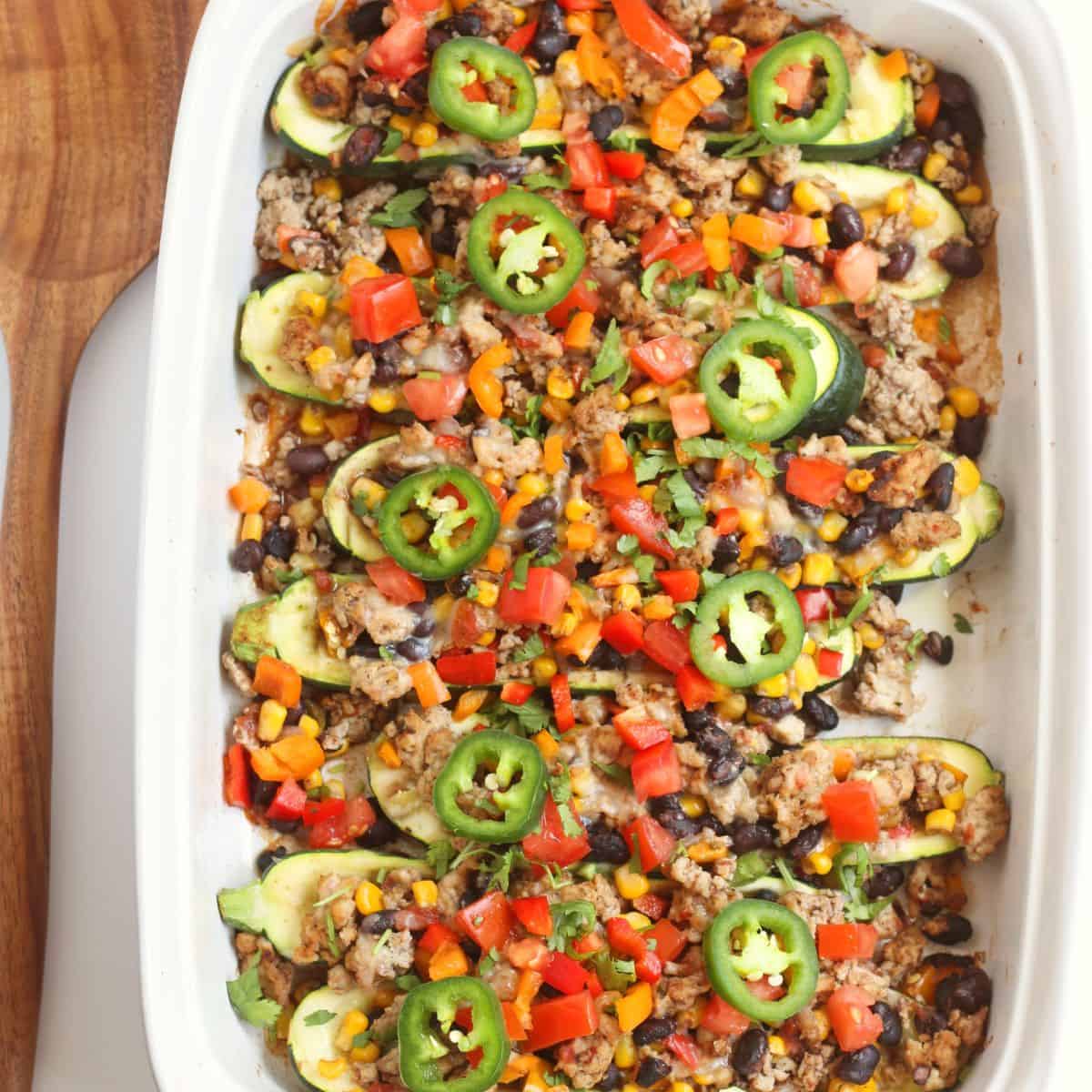 A casserole dish with taco stuffed zucchini.