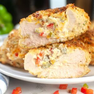 Chicken breasts stuffed with peppers and cheese on a plate.