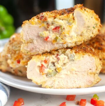 Chicken breasts stuffed with peppers and cheese on a plate.