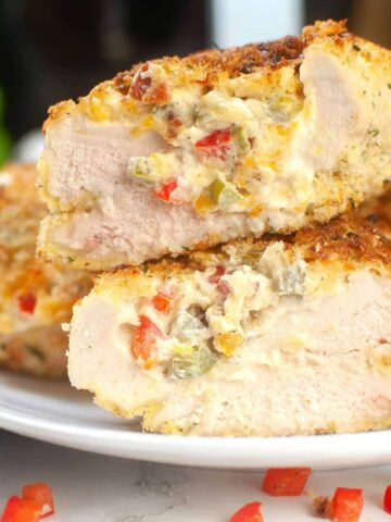 Chicken breasts stuffed with peppers and cheese on a plate.
