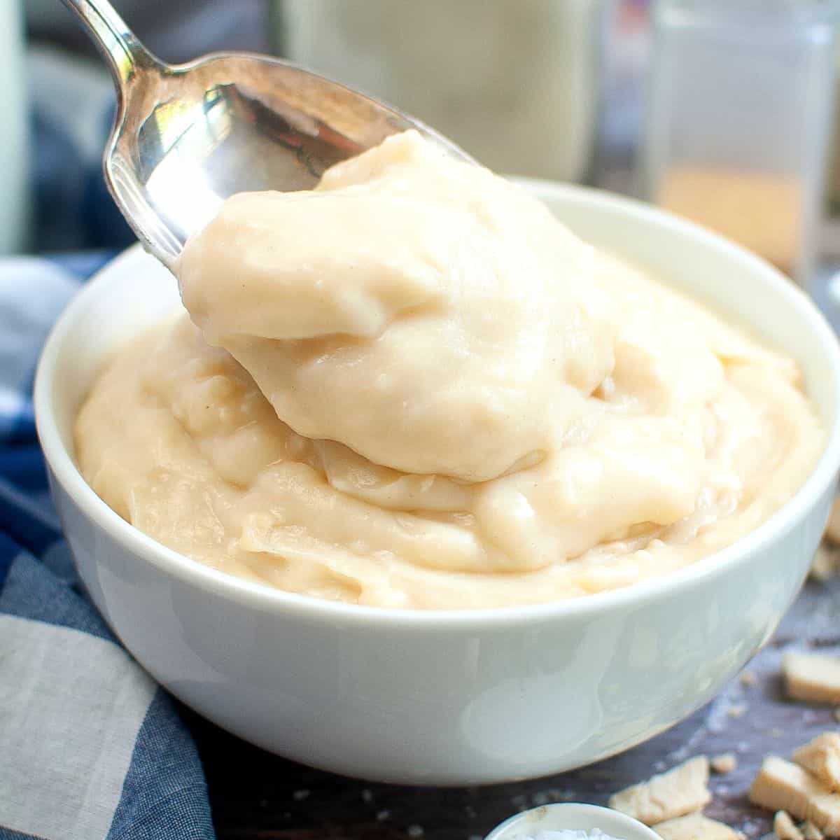 A white bowl of condensed cream of chicken soup with a spoon in the bowl.