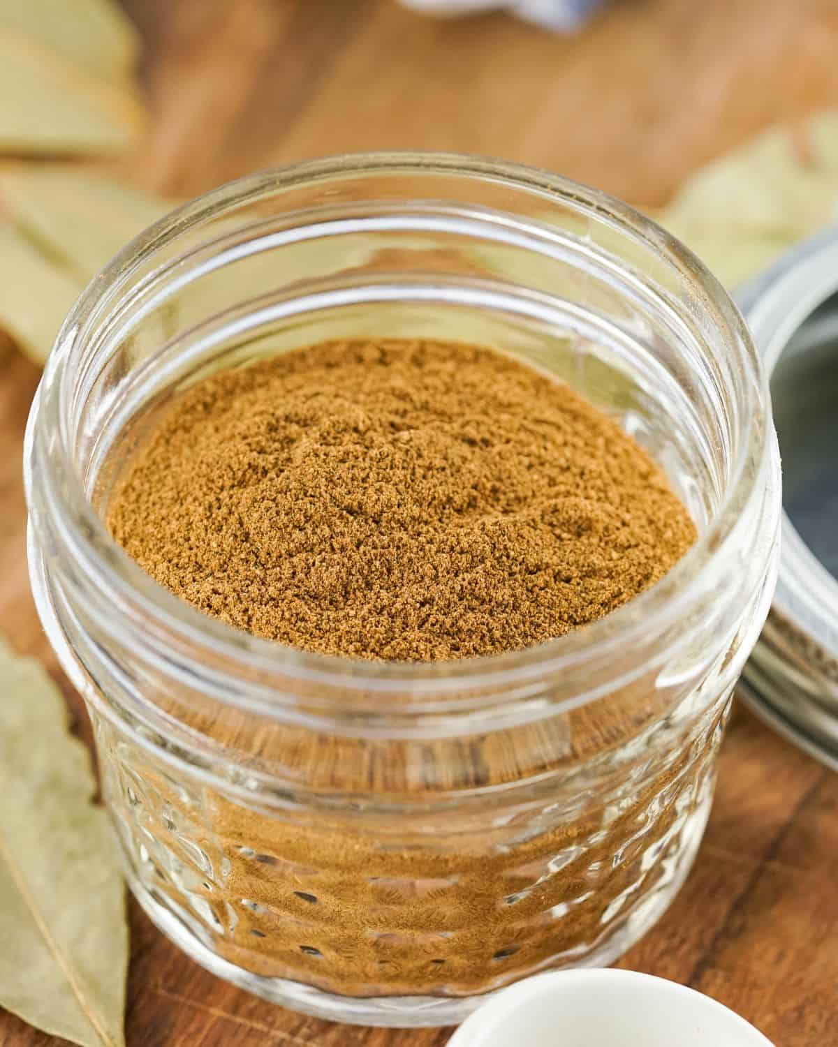 A mason jar with brown spices in the jar.