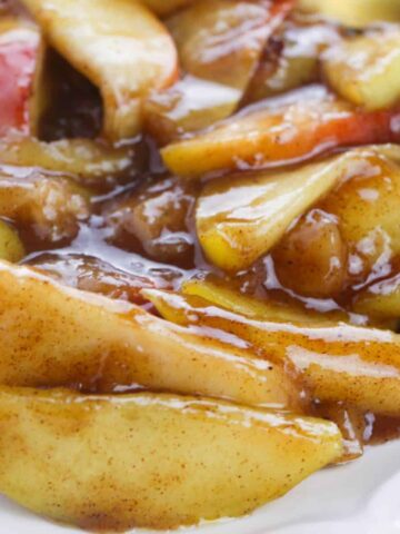 a bowl of sliced cooked apples in a brown sauce.