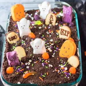 A chocolate cake decorated with ghosts, pumpkins, and sprinkles for Halloween