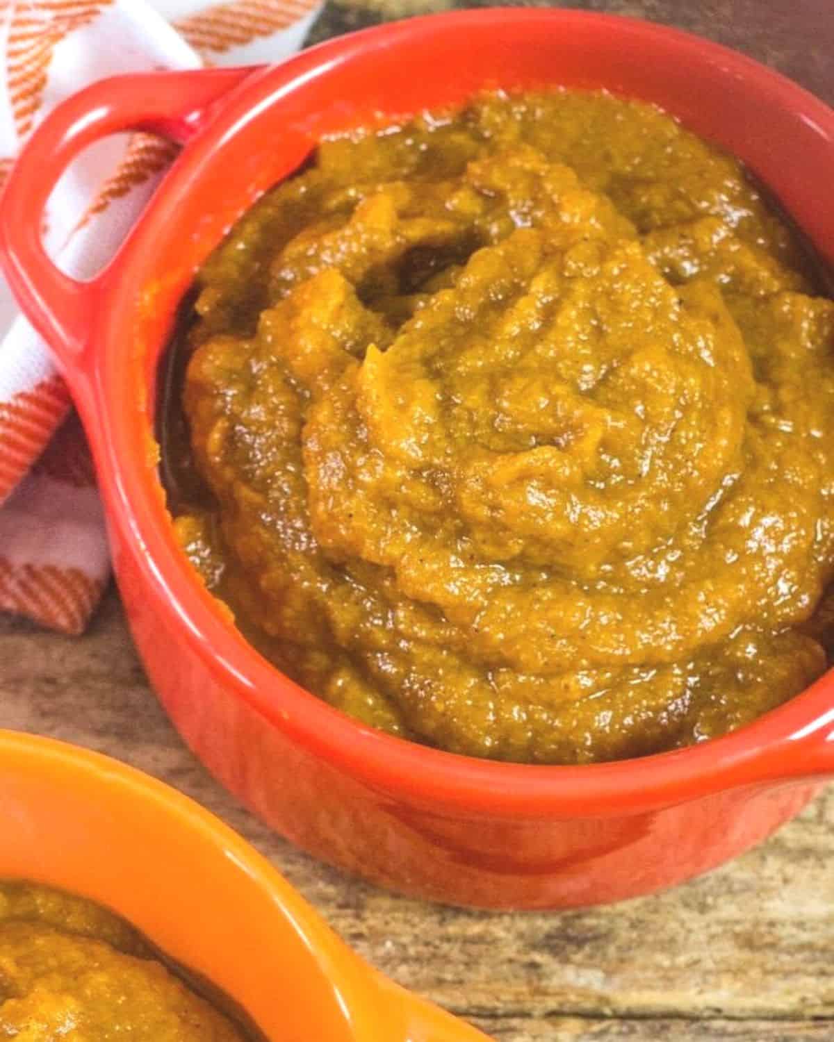 A red pot with creamy pumpkin butter in the pot.r 