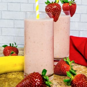 Two glasses of pink smoothies with bananas and smoothies.