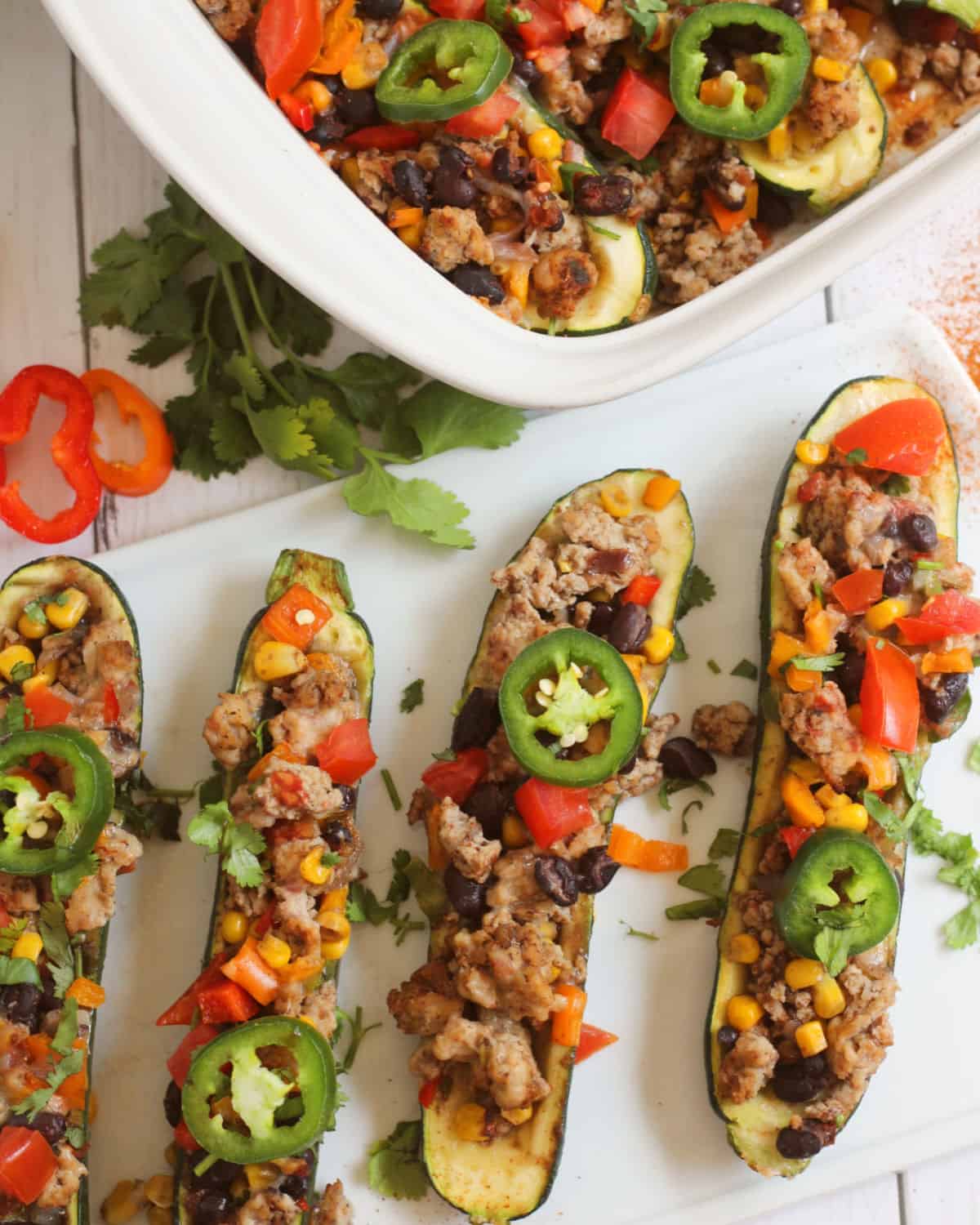 Taco Stuffed zucchini with a casserole dish of more zucchini taco boats. 