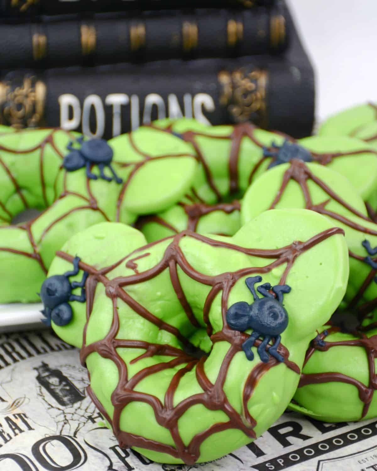  Halloween Spider Donuts with chocolate spider webs on a green mickey mouse donut. 