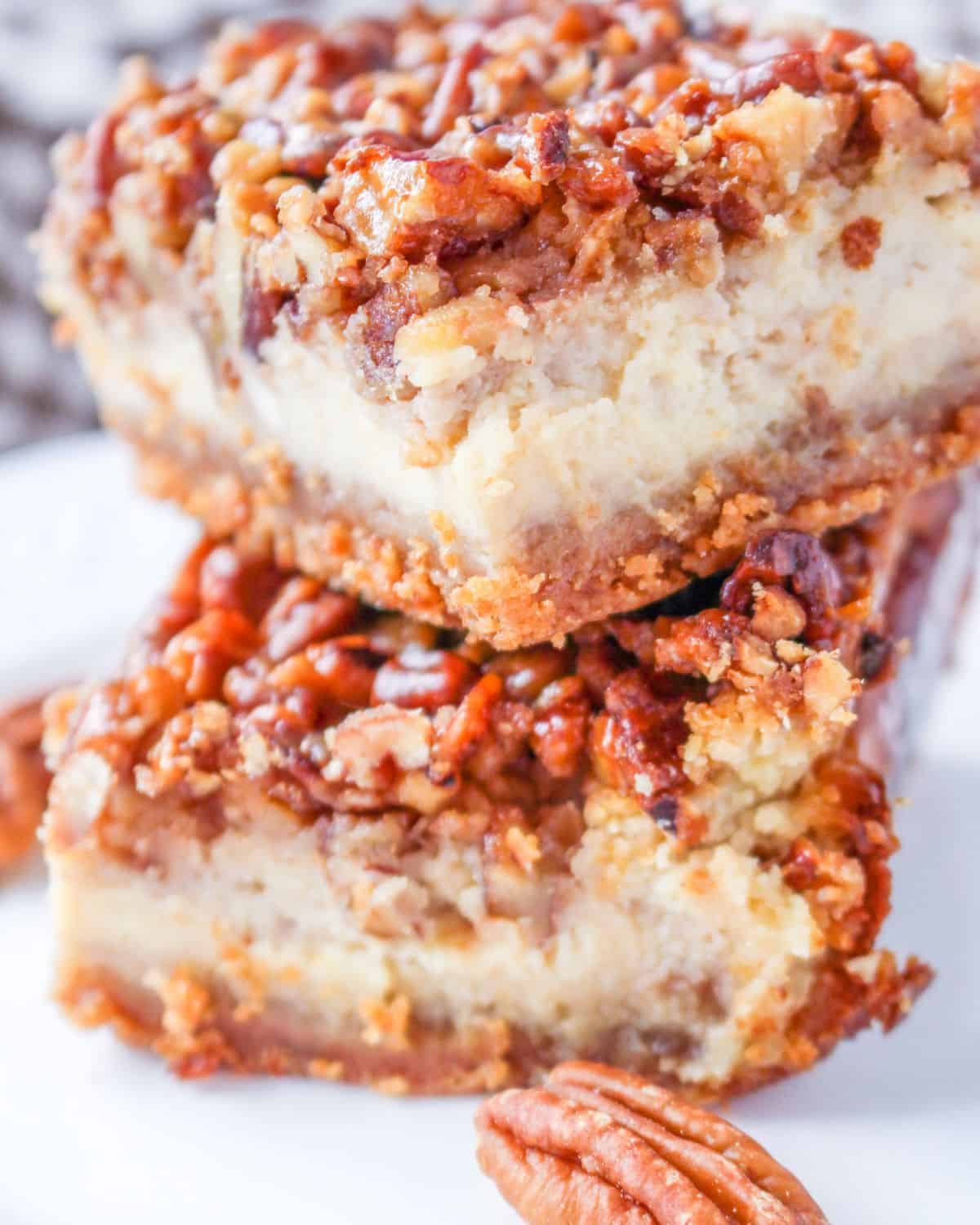 Pecan Pie Cheesecake bars stacked on a plate. 