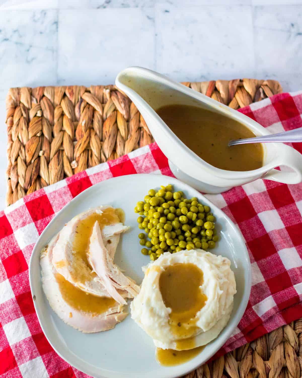 Turkey gravy over mashed potatoes and turkey on a plate.