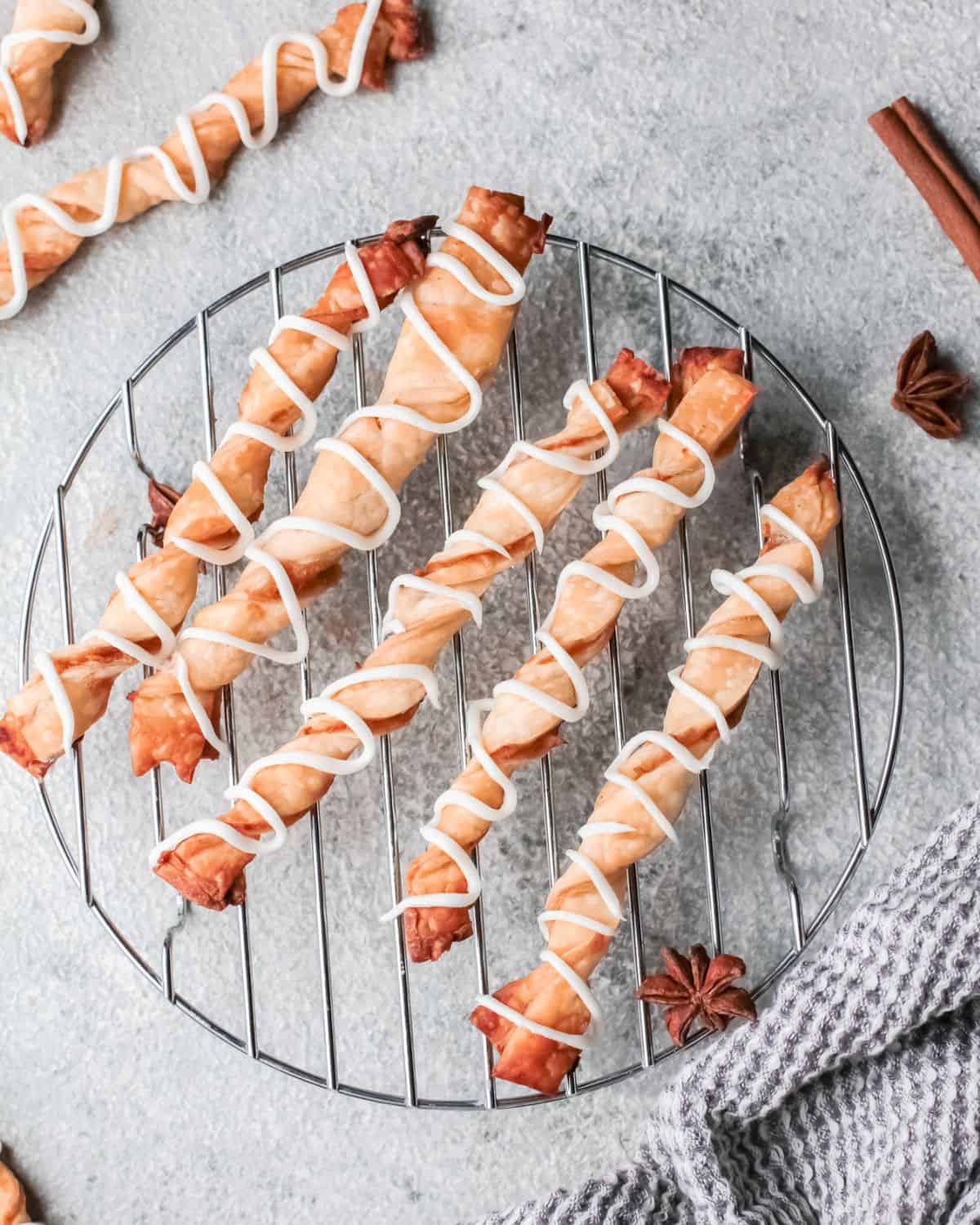 An overhead view of puff pasty filled with apple filling and spice on a wire rack.