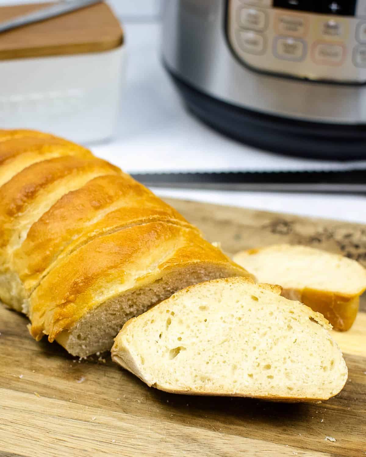 A loaf of french bread sliced on a cutting board.