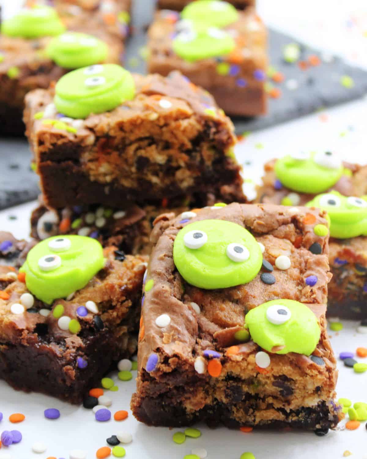 Sliced Halloween brownies with green monster faces with eyes and decorative sprinkles. 