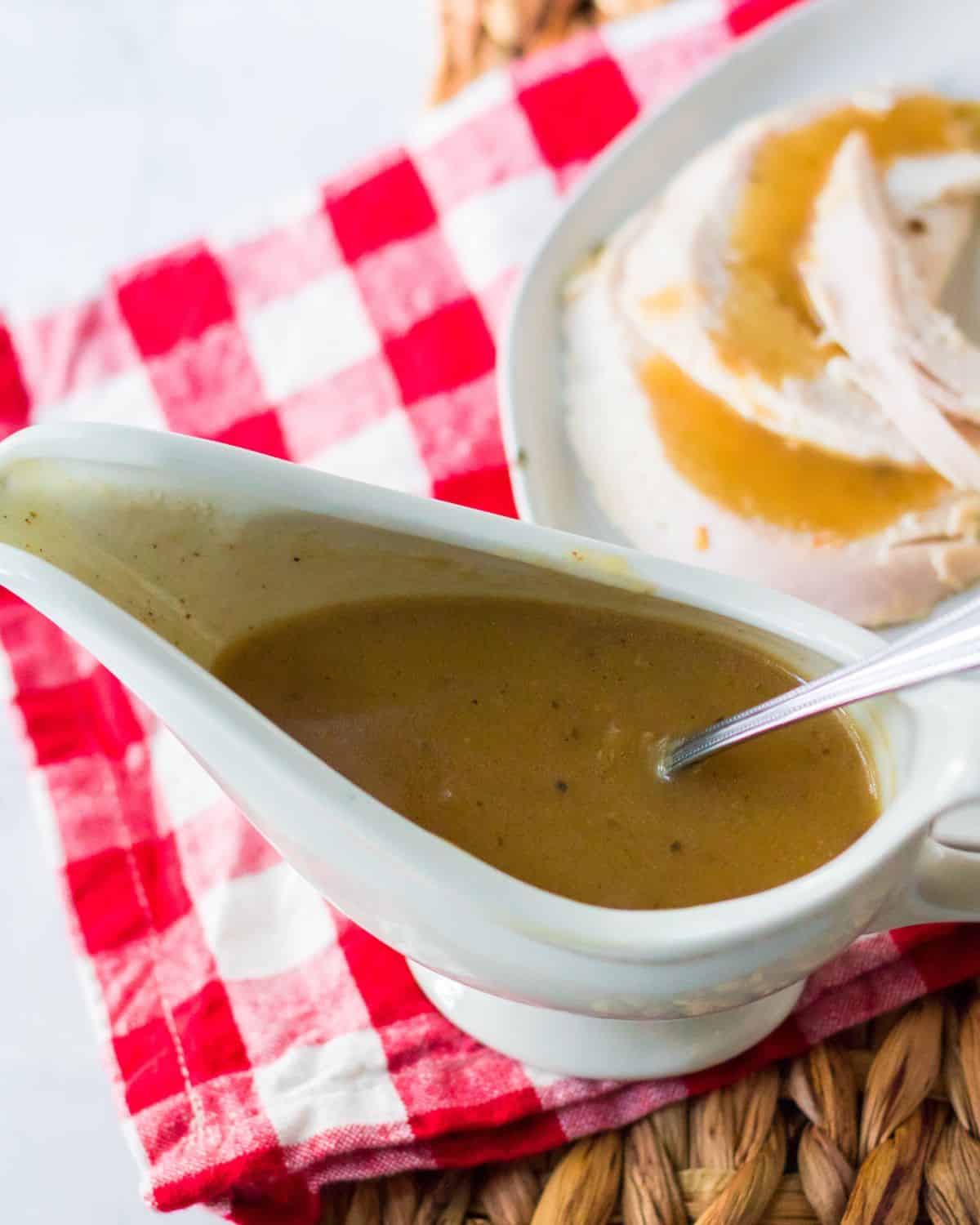 A white gravy boat with make ahead turkey gravy in the bowl.