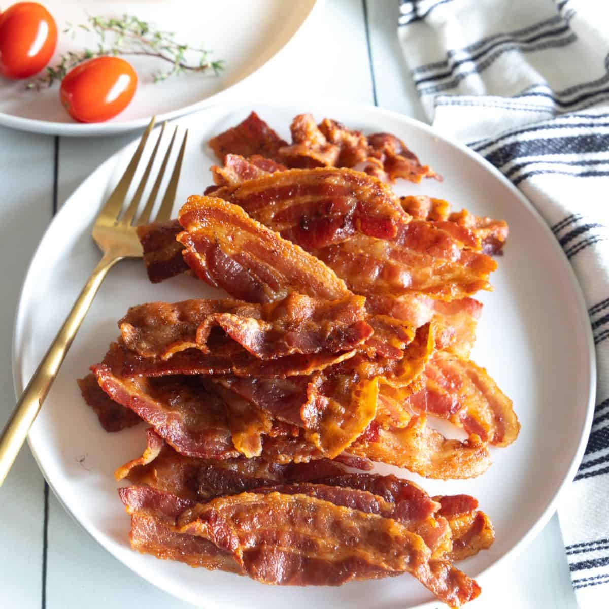 Bacon made in the air fryer on a large white plate. 