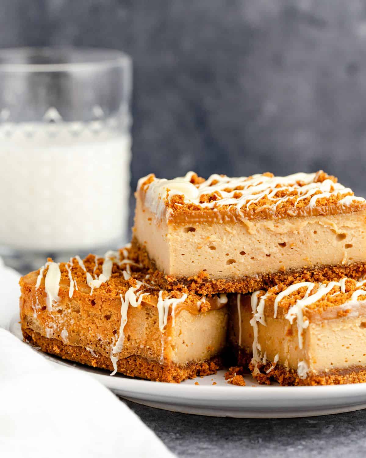A stack of cheesecake bars made with Biscoff cookie butter and Biscoff cookies on a plate.