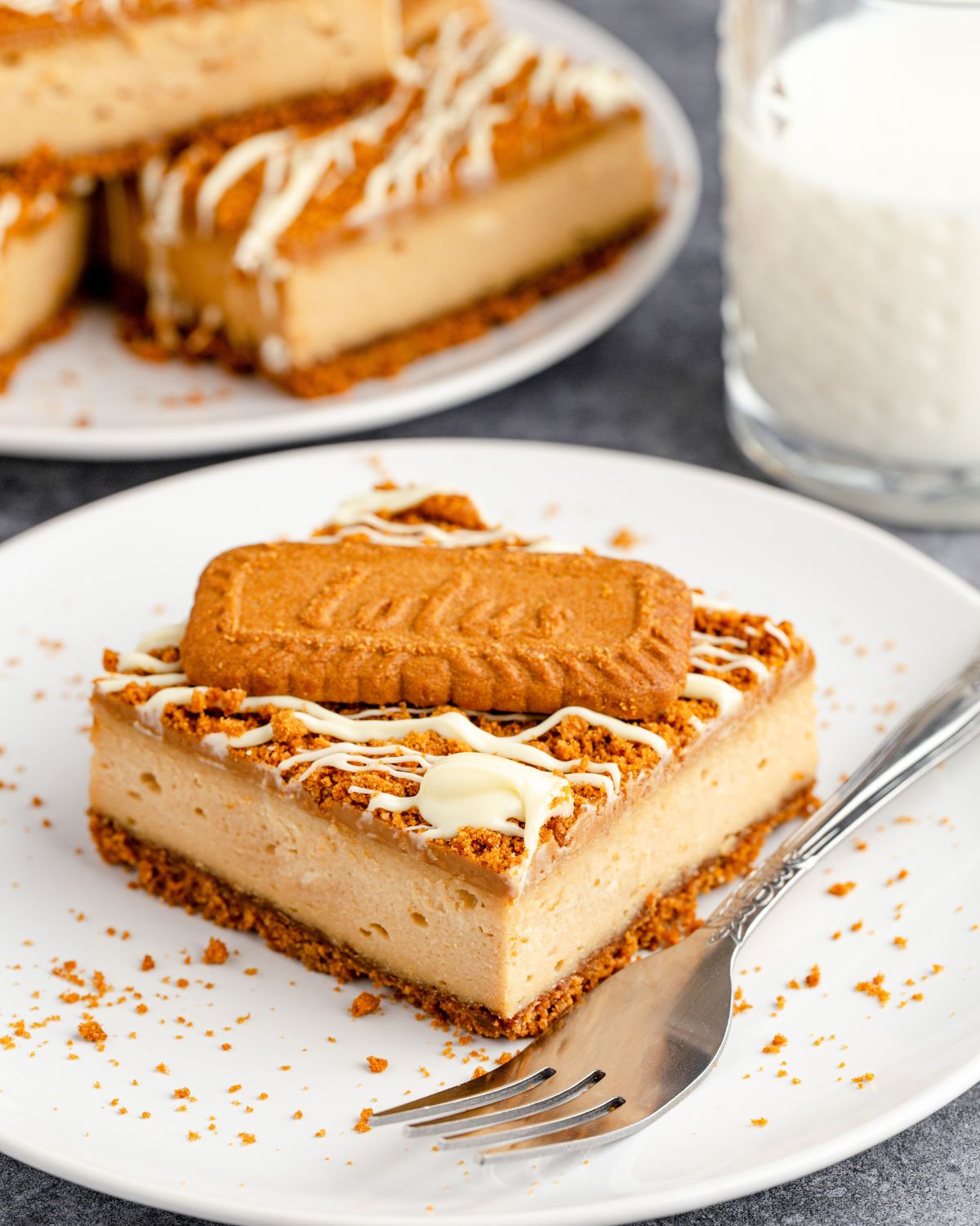 A slice of biscoff cheesecake bar on a white plate.