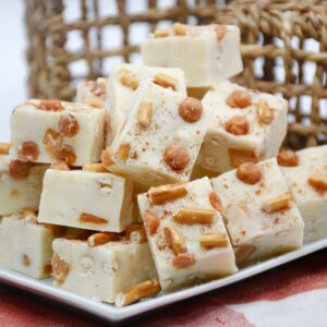 A tray of sliced white chocolate fudge with caramel bits and pretzel pieces.