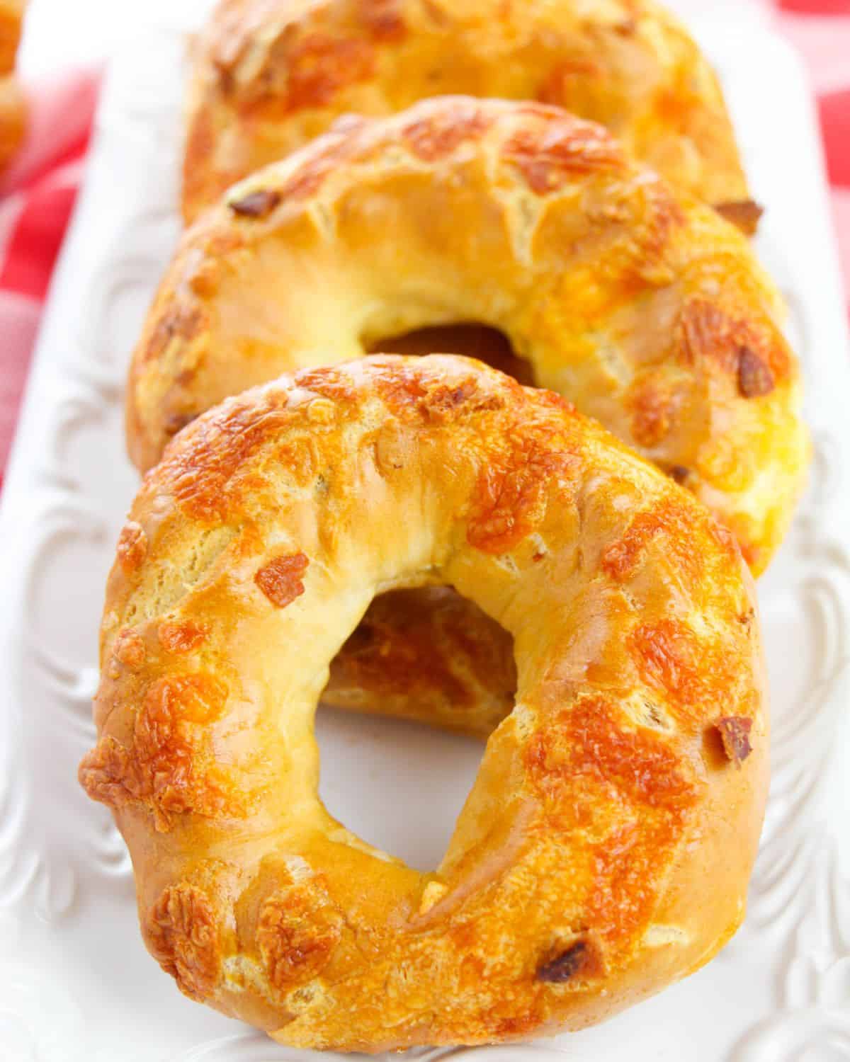 A row of cheddar bagels with bacon.